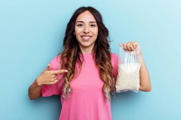 Joven Mujer Raza Mixta Sosteniendo Avena Aislada Sobre Fondo Azul —  Fotos de Stock