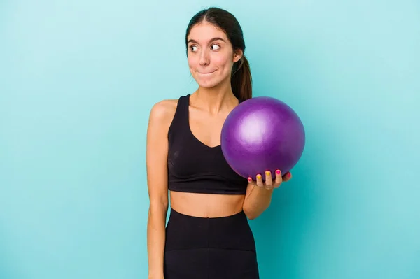 Junge Kaukasische Fitness Frau Hält Ball Isoliert Auf Blauem Hintergrund — Stockfoto