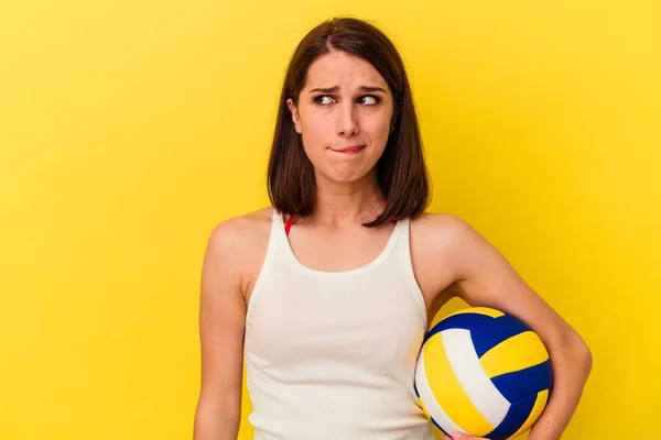 Mujer Caucásica Joven Jugando Voleibol Aislado Sobre Fondo Amarillo Confundido —  Fotos de Stock