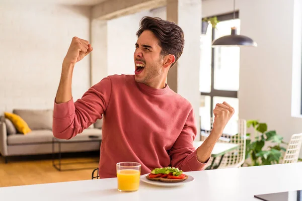 Jeune Homme Métis Prenant Petit Déjeuner Dans Cuisine Levant Poing — Photo