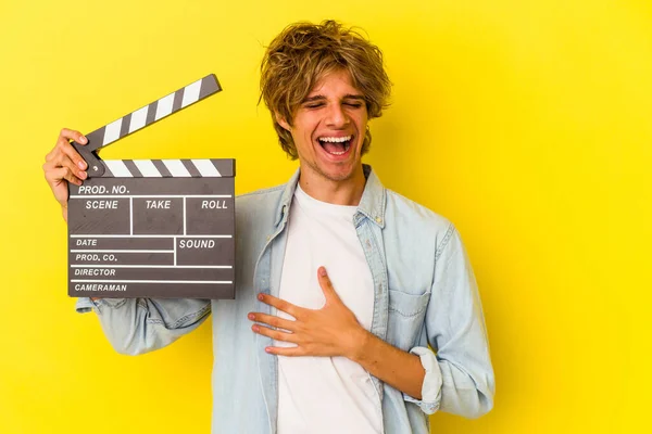 Young Caucasian Man Makeup Holding Clapperboard Isolated Yellow Background Laughs — Stock Photo, Image