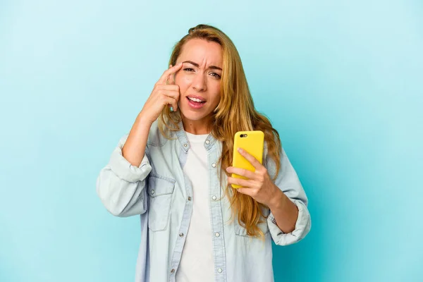 Mavi Arka Planda Cep Telefonu Tutan Beyaz Kadın Işaret Parmağıyla — Stok fotoğraf