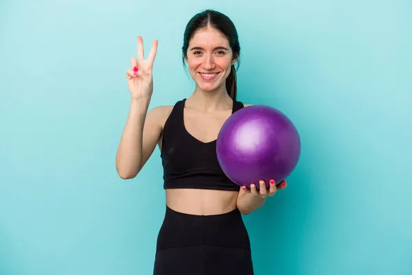 Jonge Kaukasische Fitness Vrouw Houden Een Bal Geïsoleerd Blauwe Achtergrond — Stockfoto