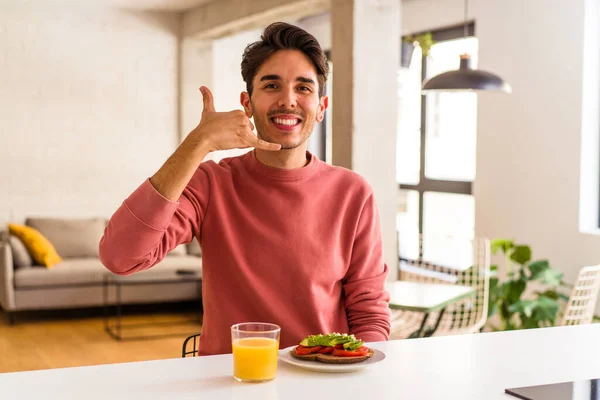 Joven Hombre Raza Mixta Desayunando Cocina Mostrando Gesto Llamada Telefónica — Foto de Stock