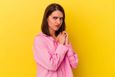 Sarı arka planda izole edilmiş genç beyaz kadın korkmuş ve korkmuş..