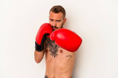 Beyaz arka planda dövmeleri olan beyaz tenli genç boksör.