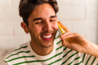 Genç melez adam koltuğunda telefonla konuşuyor.