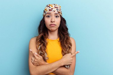 Mavi arka plan noktalarında izole edilmiş genç Meksikalı kadın iki seçenek arasında seçim yapmaya çalışıyor..