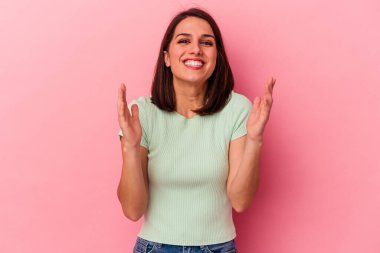 Pembe arka planda soyutlanmış beyaz bir kadın yüksek sesle gülüyor ve elini göğsüne koyuyor..