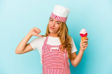 Mavi arka planda izole edilmiş dondurma tutan Kafkas dondurma üreticisi kadın gururlu ve kendinden emin hissediyor, örnek olarak.