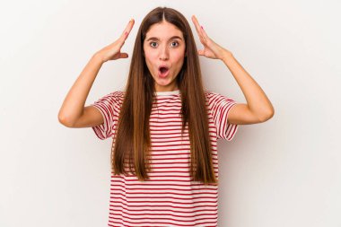 Beyaz arka planda izole genç beyaz kadın zaferi ya da başarıyı kutluyor, şaşırıyor ve şok oluyor..