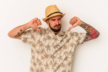 Beyaz arka planda izole edilmiş yazlık giysiler giyen beyaz dövmeli genç beyaz adam gururlu ve kendinden emin hissediyor, örnek olarak.