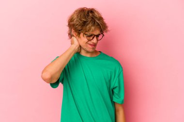 Makyajlı beyaz bir adam pembe arka planda izole edilmiş. Stres yüzünden boynu ağrıyor. Masaj yapıyor ve elle dokunuyor..