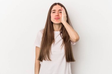 Beyaz arka planda izole edilmiş genç beyaz kadın yorgun ve uykulu ellerini başının üstünde tutuyor..