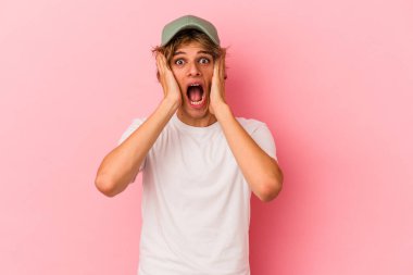 Makyajlı beyaz bir adam pembe arka planda izole edilmiş bağırıyor, çok heyecanlı, tutkulu, bir şeyden memnun..