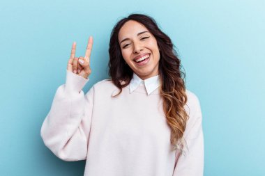 Mavi arka planda izole edilmiş genç Meksikalı kadın boynuzlarını devrim konsepti olarak gösteriyor..