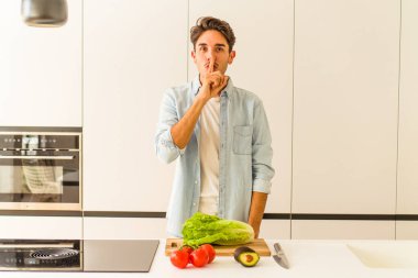 Genç melez adam öğle yemeği için salata hazırlıyor ya sır saklıyor ya da sessizlik istiyor..