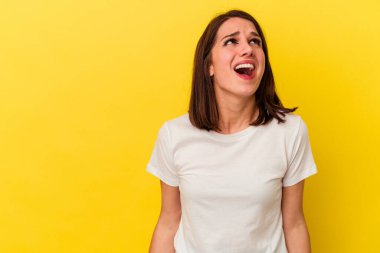 Sarı arka planda izole edilmiş genç beyaz kadın çok kızgın, öfkeli, hayal kırıklığına uğramış.