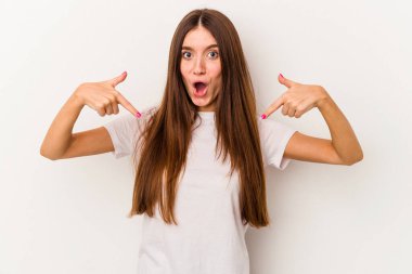 Beyaz arka planda izole genç beyaz kadın parmaklarıyla aşağı noktalar, olumlu duygu.