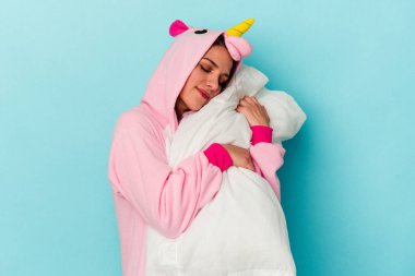 Mavi arka planda tek boynuzlu at pijaması giyen beyaz bir kadın.