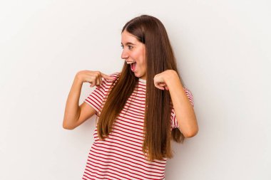 Beyaz arka planda izole edilmiş genç beyaz bir kadın parmağını göstererek şaşırdı, geniş bir gülümsemeyle..