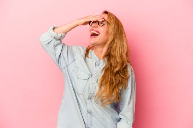 Pembe arka planda izole edilmiş beyaz, sarışın kadın mutlu bir şekilde ellerini başının üstünde tutuyor. Mutluluk kavramı.