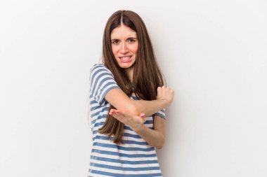 Beyaz arka planda izole edilmiş genç beyaz bir kadın. Dirsek masajı yapıyor. Kötü bir hareketin ardından acı çekiyor..