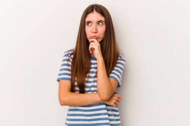 Beyaz arka planda soyutlanmış beyaz tenli genç bir kadın şüpheli ve şüpheci bir ifadeyle yana bakıyor..