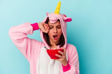 Mavi arka planda tek boynuzlu at pijaması giyen beyaz bir kadın.