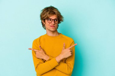 Mavi arka plan noktalarında izole edilmiş beyaz makyajlı genç bir adam iki seçenek arasında seçim yapmaya çalışıyor..