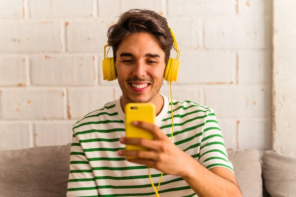 Jovem Mestiço Ouvindo Música Sentada Sofá — Fotografia de Stock