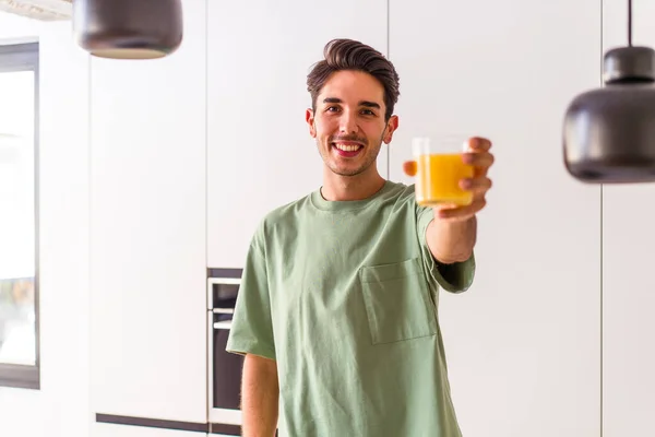 Молодой Человек Смешанной Расы Пьет Апельсиновый Сок Кухне — стоковое фото