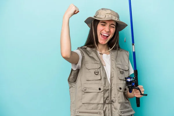 Young Caucasian Fisherwoman Isolated Blue Background Raising Fist Victory Winner — Stock Photo, Image