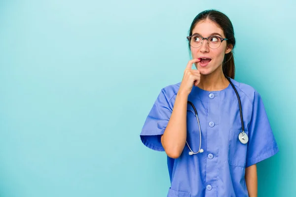 Jonge Blanke Verpleegster Geïsoleerd Blauwe Achtergrond Ontspannen Denken Iets Zoek — Stockfoto