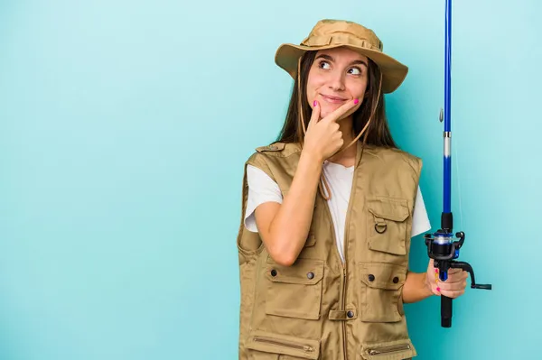 Young Caucasian Fisherwoman Isolated Blue Background Looking Sideways Doubtful Skeptical — Stock Photo, Image