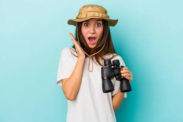 Jovem Explorador Caucasiano Mulher Segurando Binóculos Isolados Fundo Azul Surpreso — Fotografia de Stock