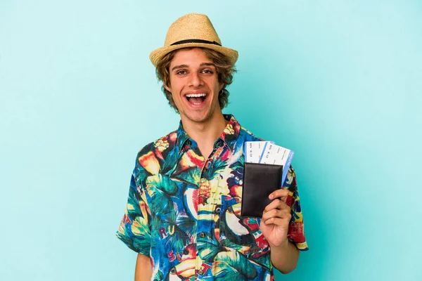青い背景に隔離されたパスポートを保持している化粧を持つ若い白人男性幸せ 笑顔と陽気な — ストック写真