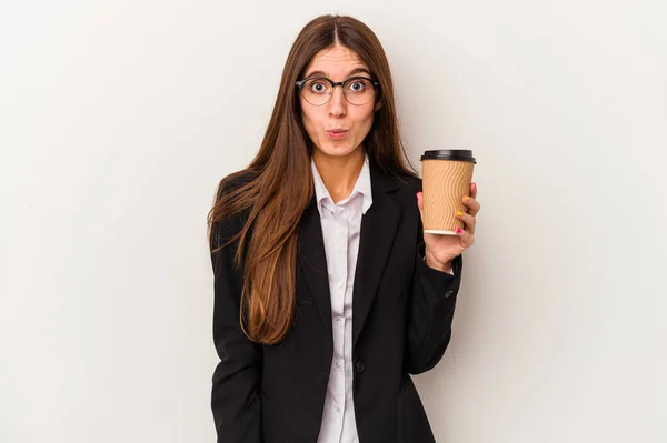 若いですCaucasianビジネス女性保持していますAテイクアウトコーヒー隔離された白い背景Shrugs肩とオープン目混乱 — ストック写真