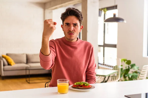 Joven Hombre Raza Mixta Desayunando Cocina Mostrando Puño Cámara Expresión — Foto de Stock
