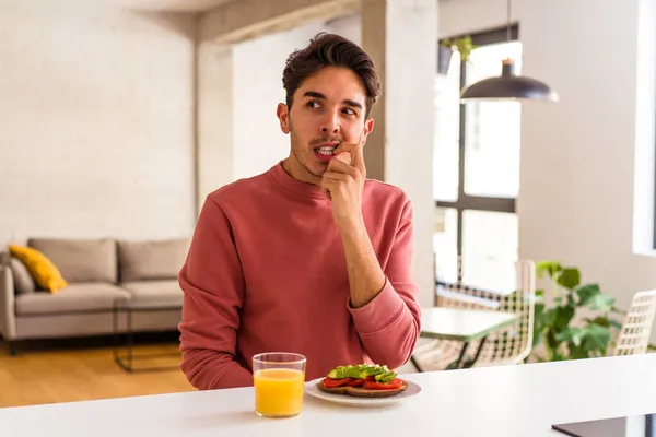 Joven Hombre Raza Mixta Desayunando Cocina Relajado Pensando Algo Mirando — Foto de Stock