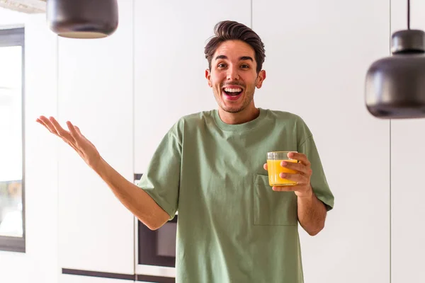 Joven Hombre Raza Mixta Bebiendo Jugo Naranja Cocina Recibiendo Una — Foto de Stock
