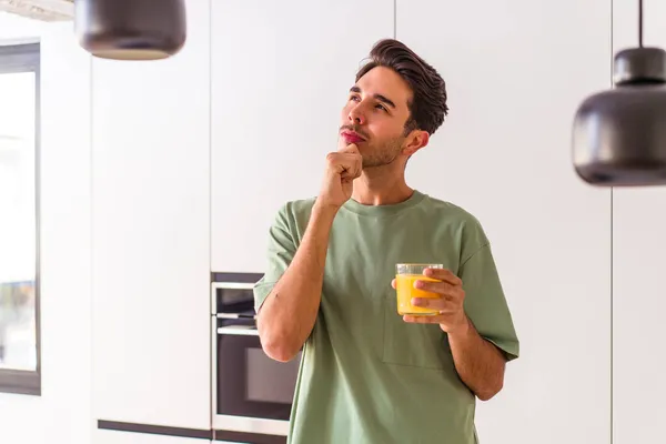 Joven Hombre Raza Mixta Bebiendo Jugo Naranja Cocina Mirando Lado — Foto de Stock
