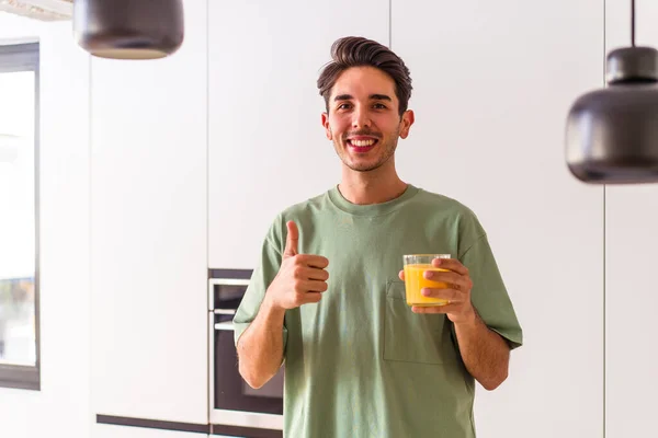 Joven Hombre Raza Mixta Bebiendo Jugo Naranja Cocina Sonriendo Levantando — Foto de Stock