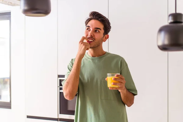 Joven Hombre Raza Mixta Bebiendo Jugo Naranja Cocina Relajado Pensando — Foto de Stock