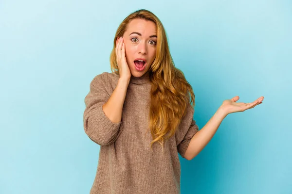 Mujer Caucásica Aislada Sobre Fondo Azul Impresionada Sosteniendo Espacio Copia — Foto de Stock