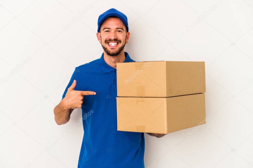 Young caucasian delivery man with tattoos isolated on white background  person pointing by hand to a shirt copy space, proud and confident