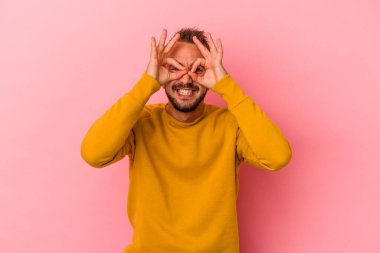 Pembe arka planda izole edilmiş beyaz dövmeli genç bir adam heyecanlı..