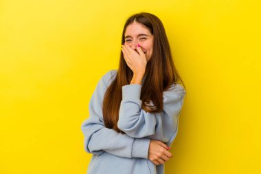 Sarı arka planda izole edilmiş genç beyaz kadın gülüyor, kaygısız, doğal duygu..