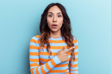 Mavi arka planda izole edilmiş genç Meksikalı kadın...