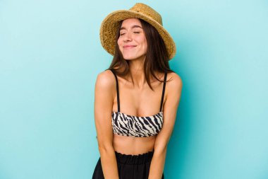 Beyazlı genç bir kadın kumsala gidiyor. Mavi arka planda izole edilmiş bir bikini giyiyor. Amaçlarına ve amaçlarına ulaşma hayali kuruyor.